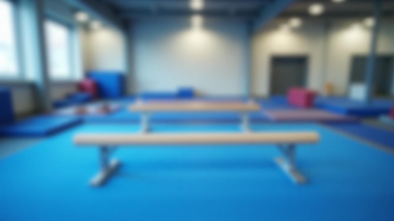 Barras asimétricas y viga de equilibrio con colchonetas protectoras en una sesión de entrenamiento.